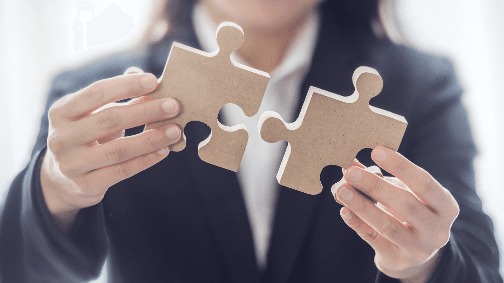 Una persona cerca di unire due pezzi di un puzzle, metafora di un'attività di uskilling