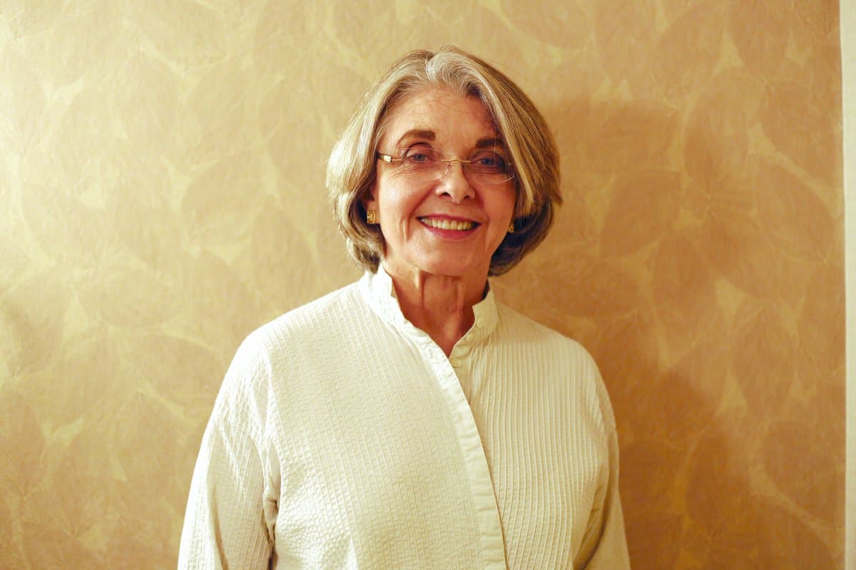 Marilyn Loden sorridente vestita in bianco