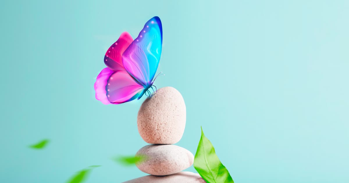 Una farfalla colorata posata su alcune pietre sovrapposte