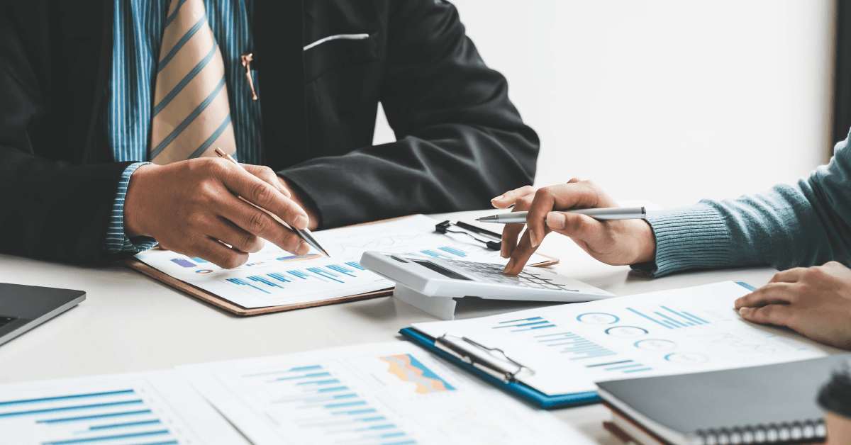 Due professionisti discutono analisi finanziarie, con enfasi sui dettagli grafici